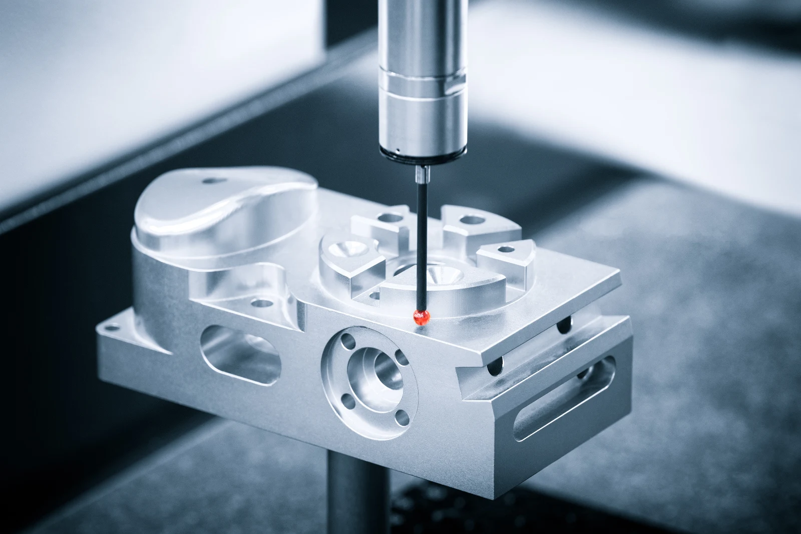 A CMM touch probe inspecting a machined aluminium block