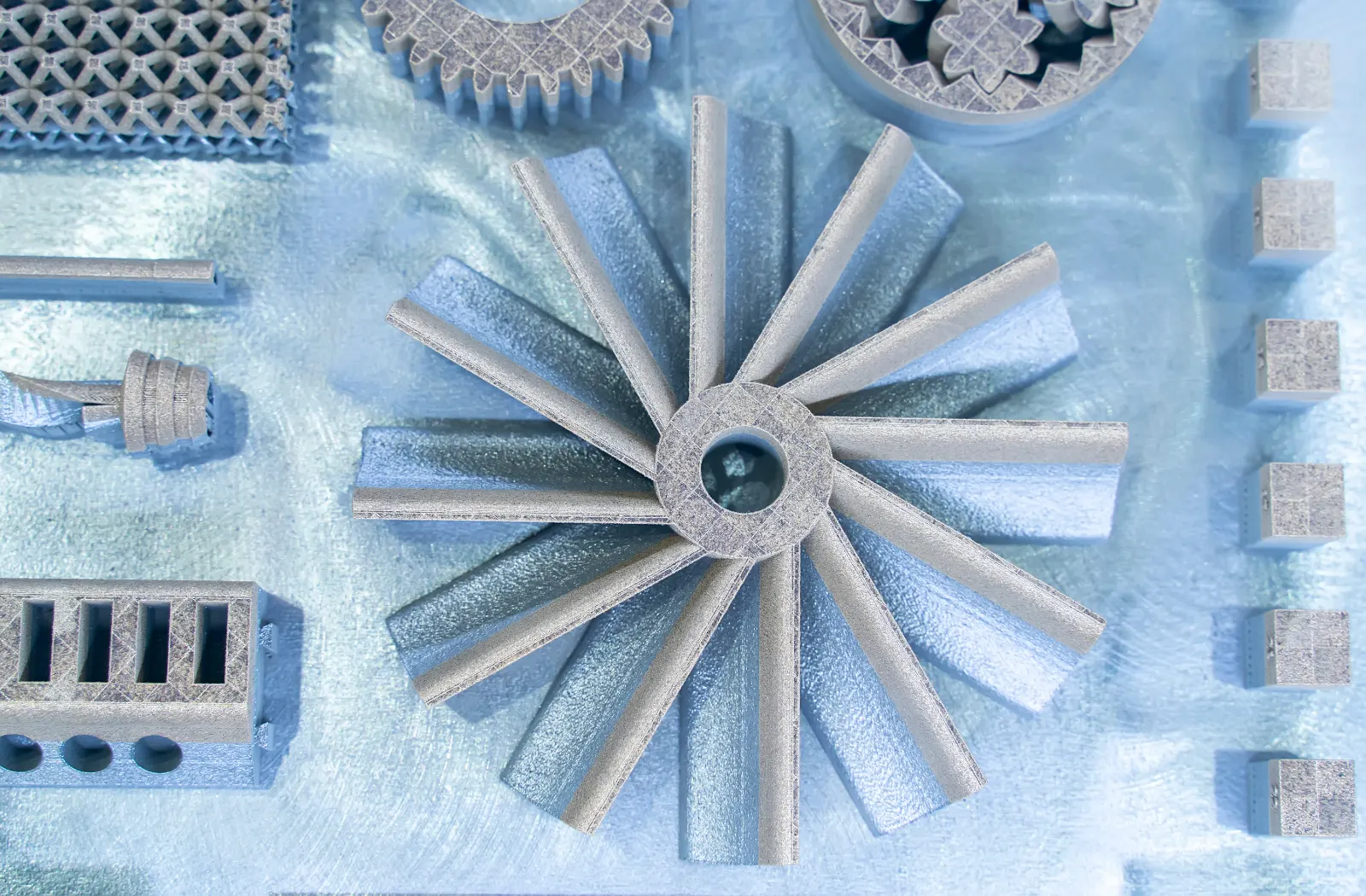 Additive manufacturing parts including an impeller and lattice blocks on the build plate