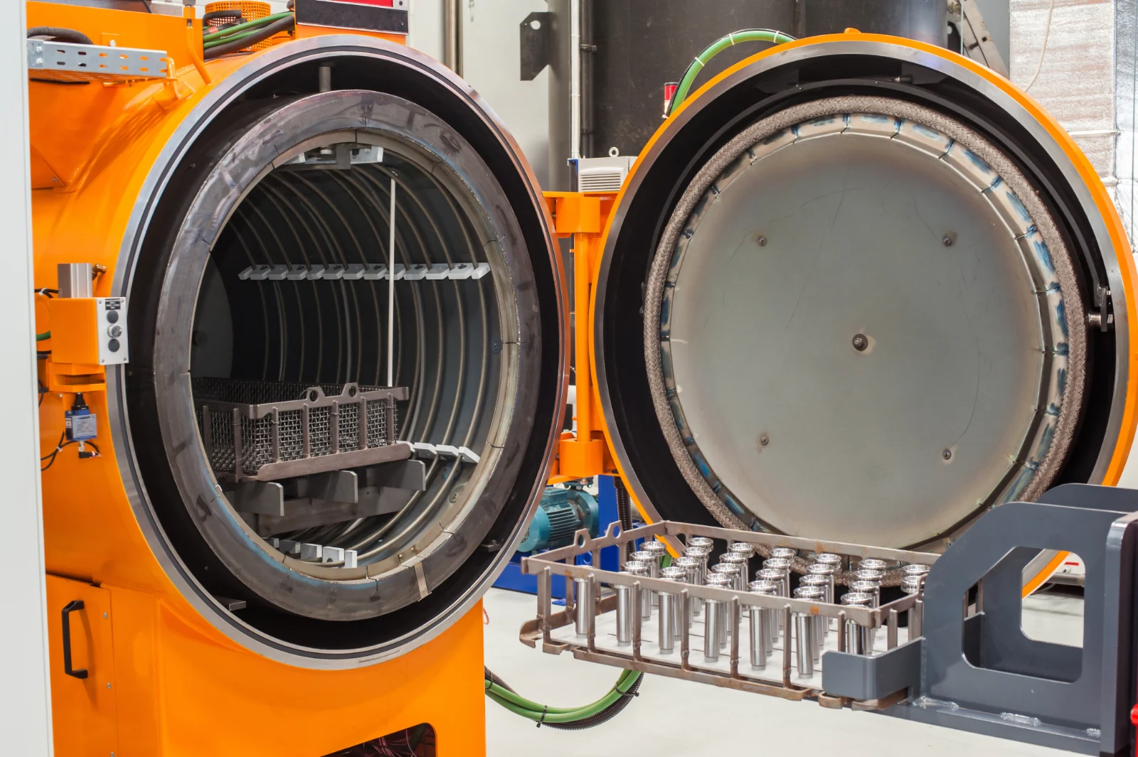 Open vacuum heat treatment furnace with a basket of metal parts ready for stress relief