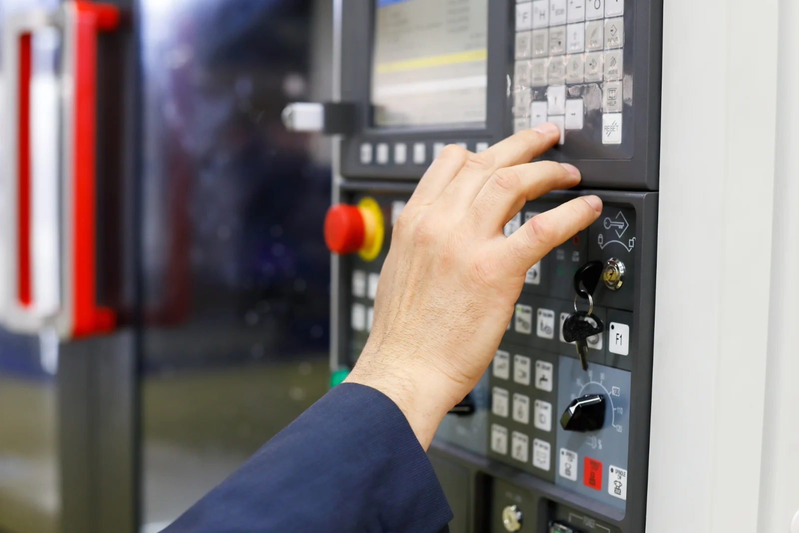 Operator keying a multi-axis program into a CNC control