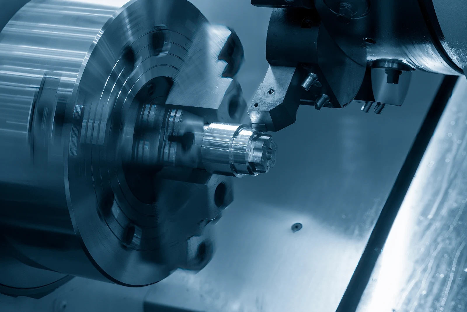 A lathe tool cutting a flanged metal component on a turning centre.